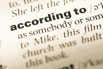 Obraz premium Close up of old English dictionary page with word according to