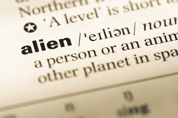 Close up of old English dictionary page with word alien