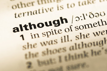 Close up of old English dictionary page with word although