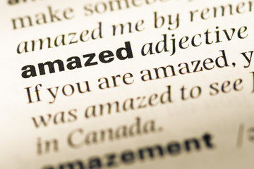 Obraz premium Close up of old English dictionary page with word amazed