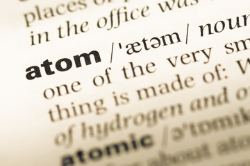Close up of old English dictionary page with word atom