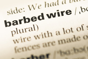 Fototapeta premium Close up of old English dictionary page with word barbed wire
