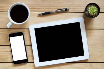 Office workplace with blank screen tablet,pen,pencil,smart phone and coffee cup on rustic wood table.Top view