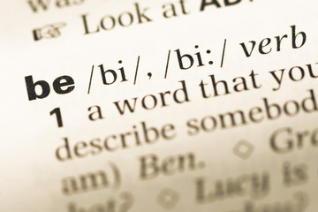 Obraz premium Close up of old English dictionary page with word be