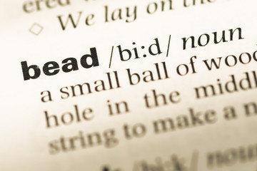Obraz premium Close up of old English dictionary page with word bead
