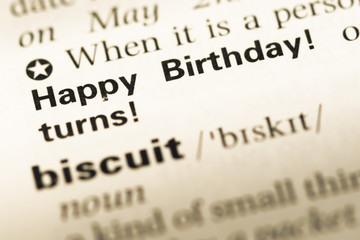 Fototapeta premium Close up of old English dictionary page with word happy birthday