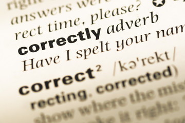 Close up of old English dictionary page with word correctly