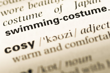 Close up of old English dictionary page with word swimming costu