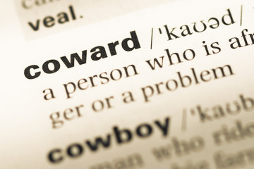 Close up of old English dictionary page with word coward