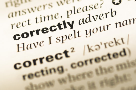 Close up of old English dictionary page with word correctly