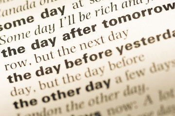 Close up of old English dictionary page with word the day after