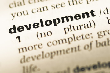 Fototapeta premium Close up of old English dictionary page with word development