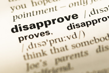 Close up of old English dictionary page with word disapprove