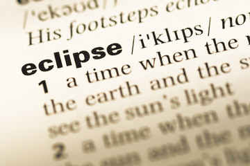Close up of old English dictionary page with word eclipse