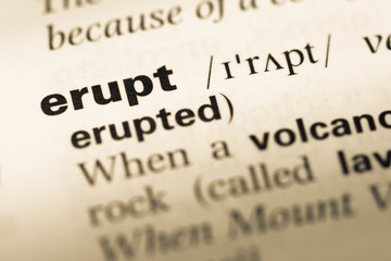 Close up of old English dictionary page with word erupt
