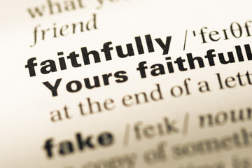 Close up of old English dictionary page with word faithfully