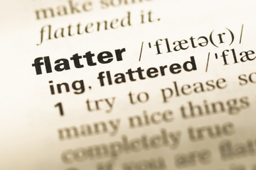 Fototapeta premium Close up of old English dictionary page with word flatter