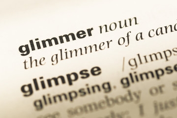 Close up of old English dictionary page with word glimmer