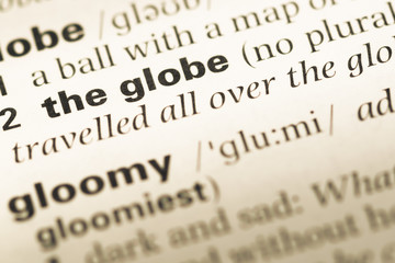 Fototapeta premium Close up of old English dictionary page with word the globe