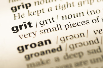 Close up of old English dictionary page with word grit - obrazy, fototapety, plakaty