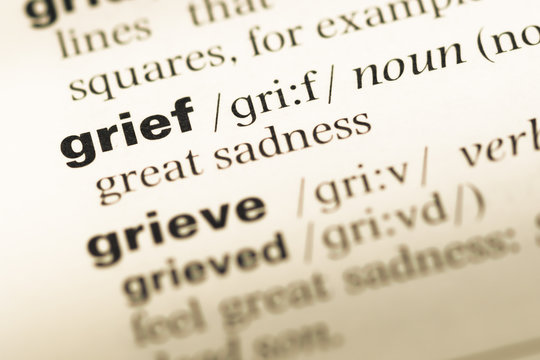 Close up of old English dictionary page with word grief