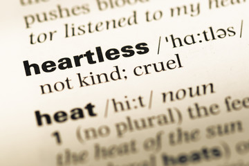 Close up of old English dictionary page with word heartless