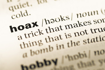 Close up of old English dictionary page with word hoax
