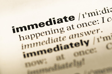 Close up of old English dictionary page with word immediate