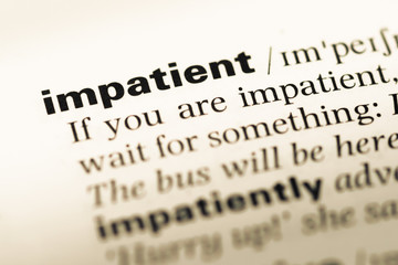 Close up of old English dictionary page with word impatient