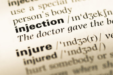 Fototapeta premium Close up of old English dictionary page with word injection