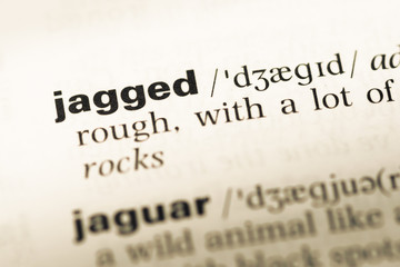 Fototapeta premium Close up of old English dictionary page with word jagged