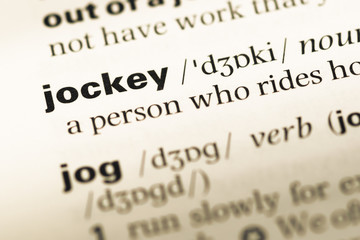 Obraz premium Close up of old English dictionary page with word jockey