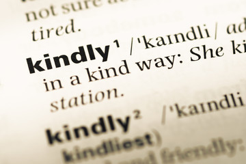 Close up of old English dictionary page with word kindly