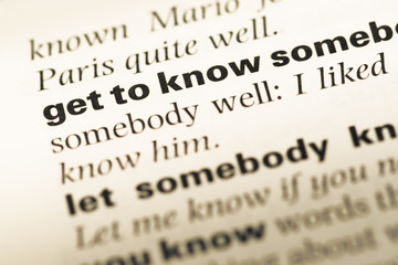 Close up of old English dictionary page with word get to know