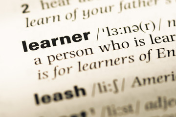 Close up of old English dictionary page with word learner
