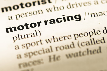 Obraz premium Close up of old English dictionary page with word motor racing