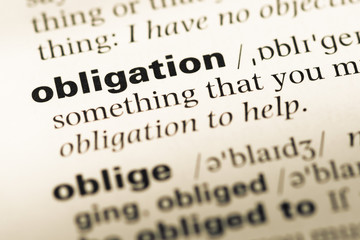 Obraz premium Close up of old English dictionary page with word obligation