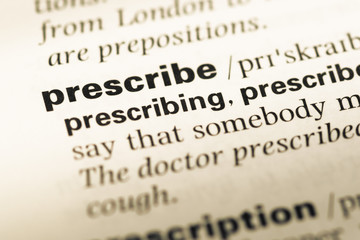 Obraz premium Close up of old English dictionary page with word prescribe