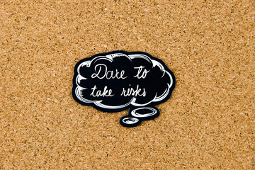 DARE TO TAKE RISKS written on black thinking bubble