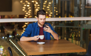 man with smartphone and coffee at restaurant