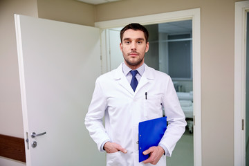 doctor with clipboard at hospital corridor