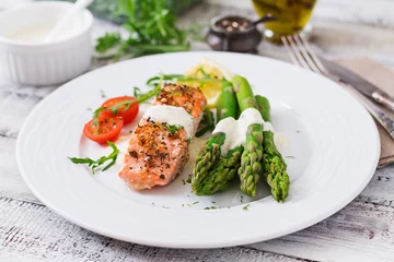 Fotobehang Baked salmon garnished with asparagus and tomatoes with herbs © timolina