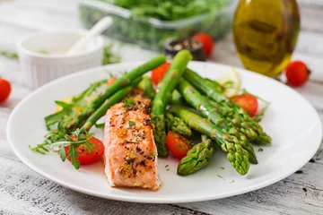 Schilderijen op glas Baked salmon garnished with asparagus and tomatoes with herbs © timolina