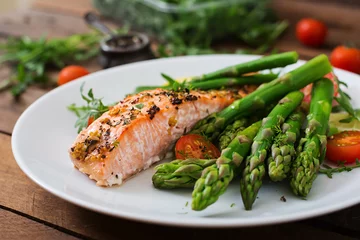 Foto auf Acrylglas Antireflex Baked salmon garnished with asparagus and tomatoes with herbs © timolina