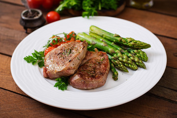 Barbecue grilled beef steak meat with asparagus and tomatoes.