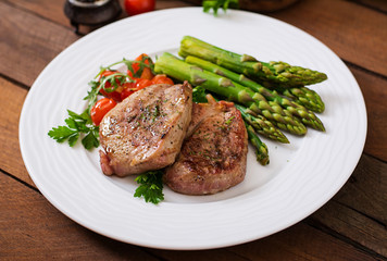 Barbecue grilled beef steak meat with asparagus and tomatoes.