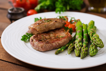 Barbecue grilled beef steak meat with asparagus and tomatoes.