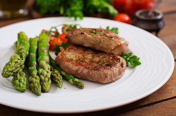 Barbecue grilled beef steak meat with asparagus and tomatoes.