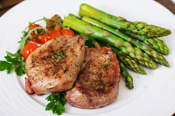 Barbecue grilled beef steak meat with asparagus and tomatoes.