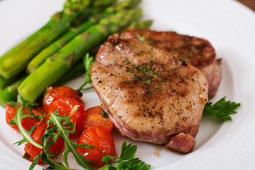 Barbecue grilled beef steak meat with asparagus and tomatoes.
